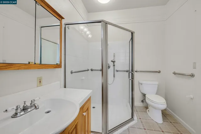 a bathroom with a sink a toilet and shower