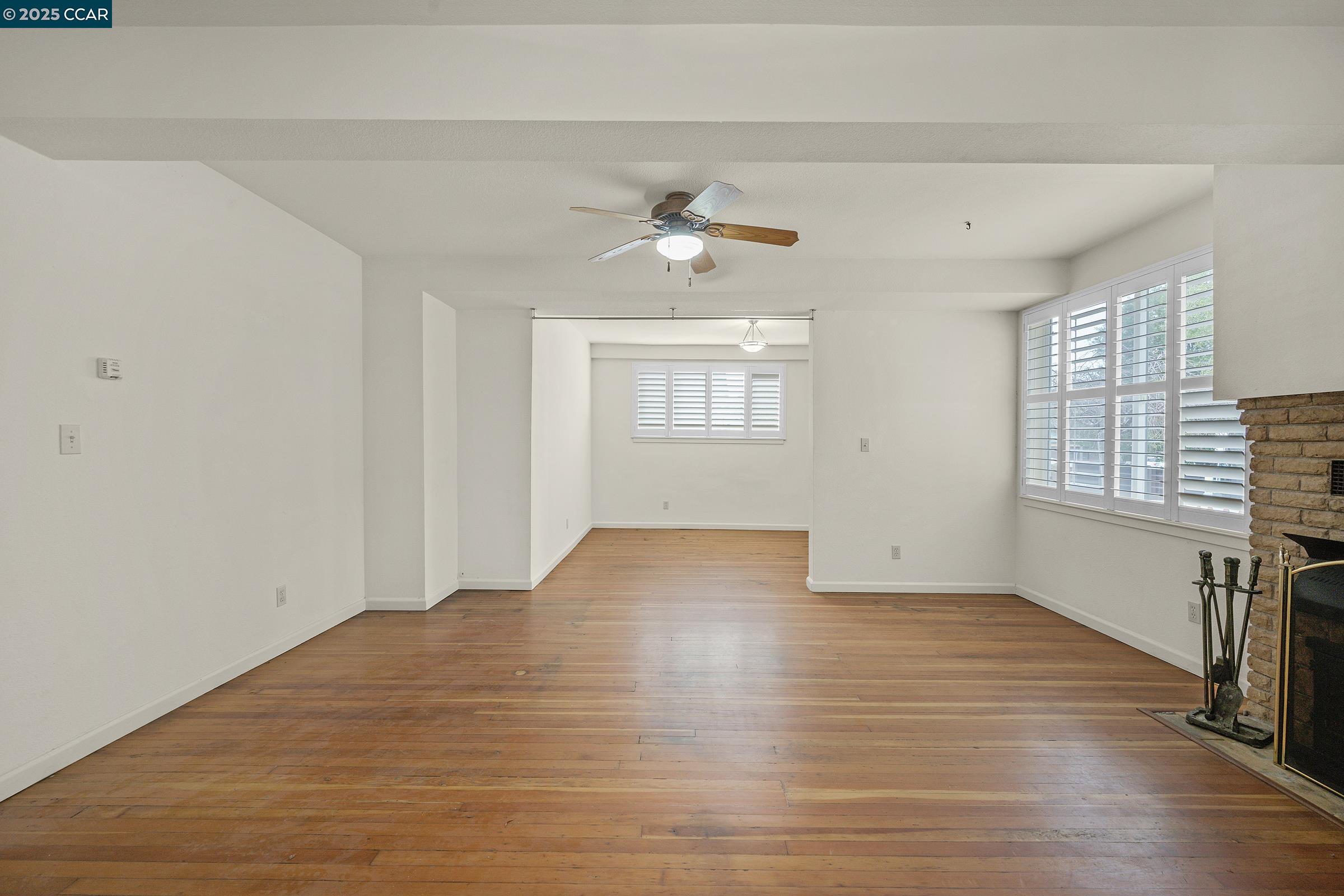 2581 Charles Avenue Pinole, CA 94564 - Photo 31 of 50 an empty room with wooden floor chandelier fan and windows