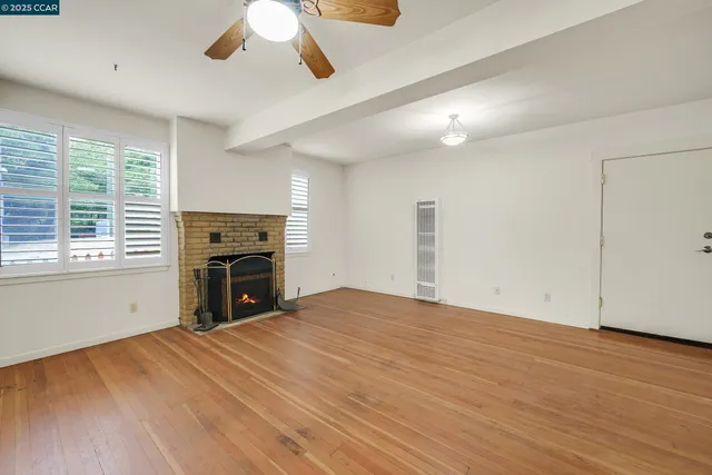 an empty room with wooden floor and window
