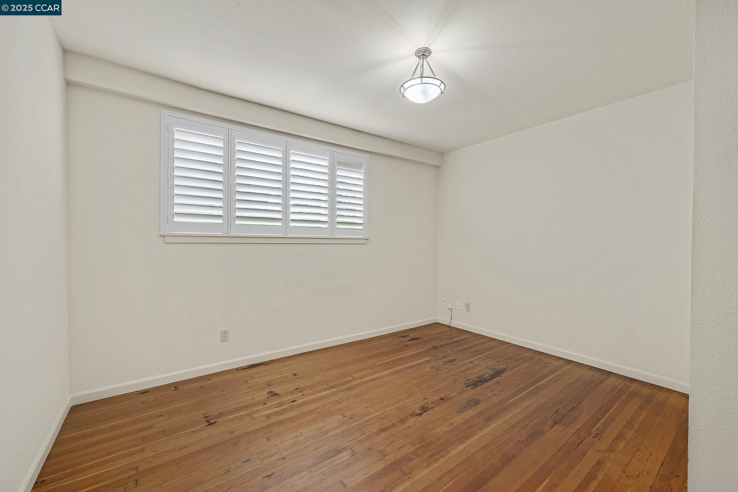 2581 Charles Avenue Pinole, CA 94564 - Photo 34 of 50 an empty room with wooden floor and window