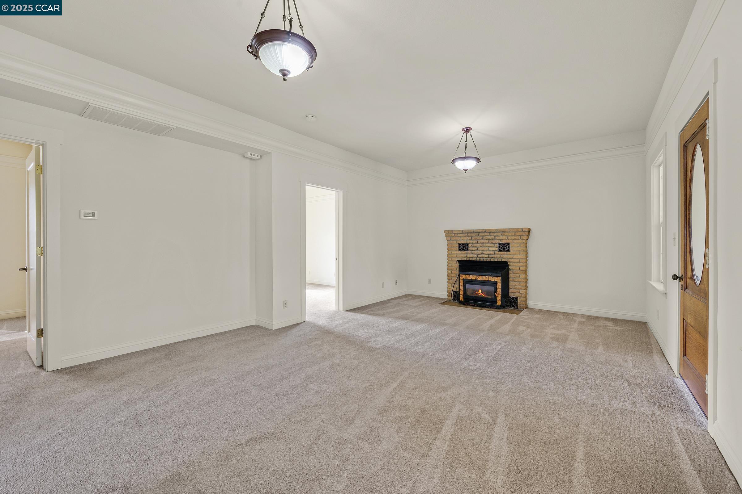 2581 Charles Avenue Pinole, CA 94564 - Photo 7 of 50 an empty room with fireplace and windows