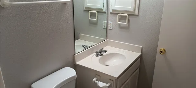 a bathroom with a sink toilet and mirror