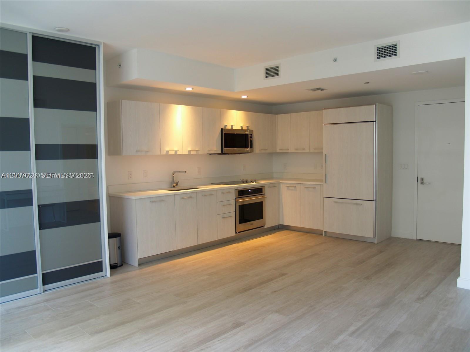 a kitchen with a refrigerator and a sink
