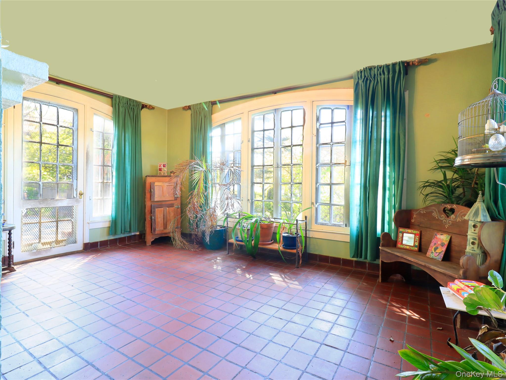11-20 Shore Road Queens, NY 11363 - Photo 26 of 45 Sunroom featuring terracotta tile flooring and a curved wall of mullioned windows