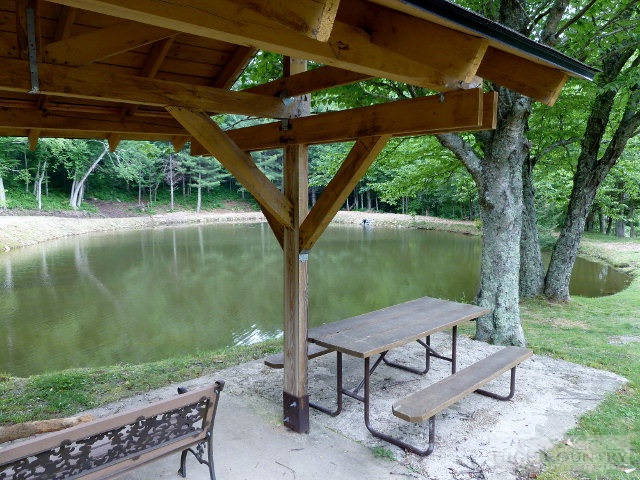 C-23 Broken Arrow Trail Boone, NC 28607 - Photo 5 of 11 a view of a lake with a table and chairs under an umbrella