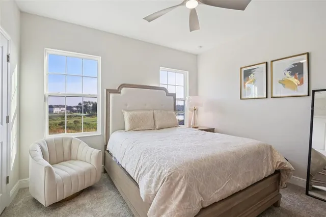 a spacious bedroom with a large bed and a chandelier