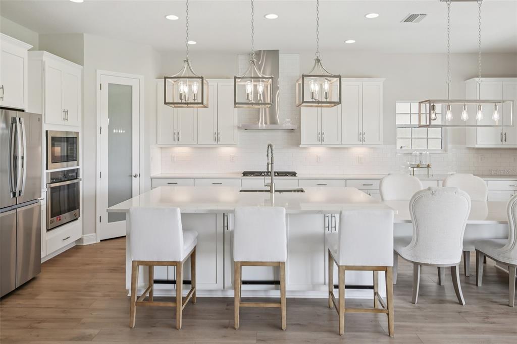 14930 Rider Pass Drive Lithia, FL 33547 - Photo 22 of 63 a kitchen with stainless steel appliances kitchen island granite countertop a dining table chairs and a refrigerator