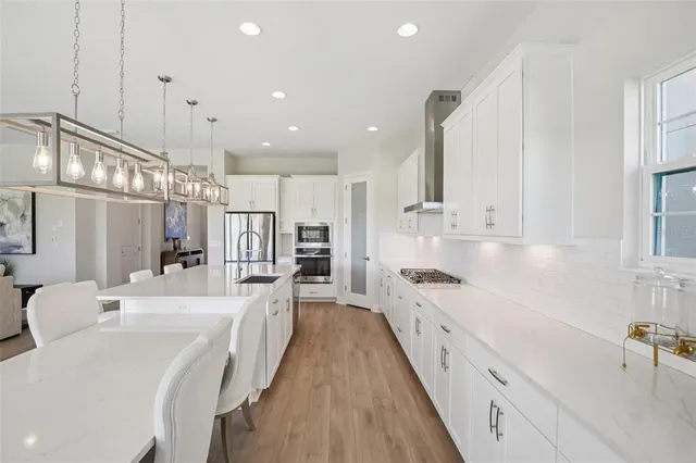 a large kitchen with kitchen island a large counter space a sink stainless steel appliances and cabinets