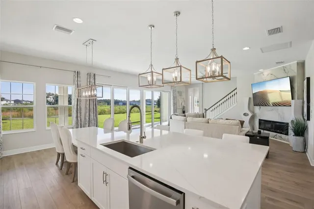 a kitchen with stainless steel appliances kitchen island granite countertop a stove a refrigerator a kitchen island with a dining table and chairs