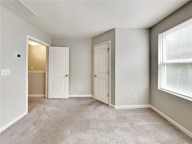 an empty room with windows and closet