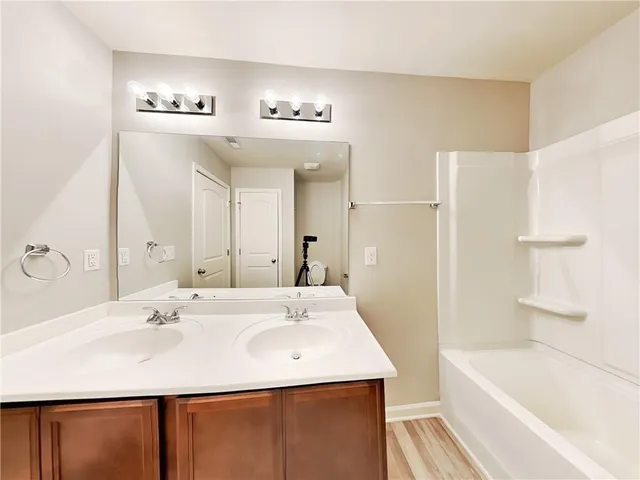 a bathroom with a bathtub a sink and a mirror