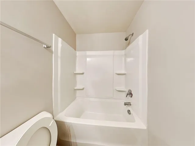 a bath room with a toilet and a bath tub