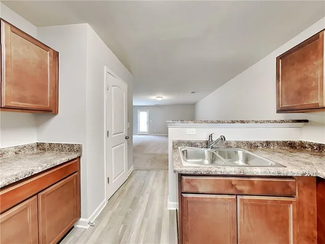 a kitchen with a granite countertop sink cabinets and stove top oven