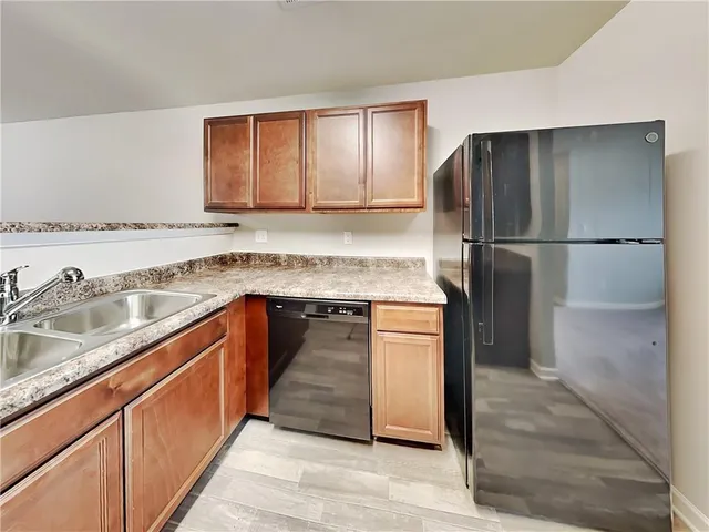 a kitchen with stainless steel appliances granite countertop a refrigerator and a sink