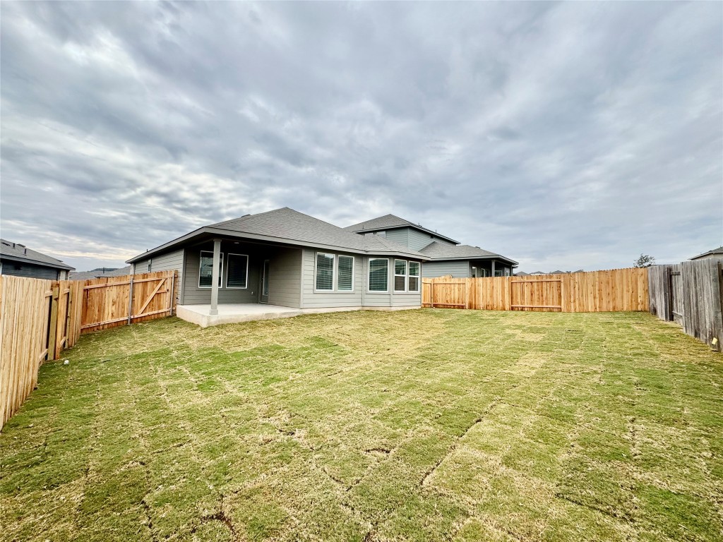 454 El Capitan Loop Dripping Springs, TX 78620 - Photo 5 of 26 Rear view of house with a patio area, a fenced backyard, and a shingled roof