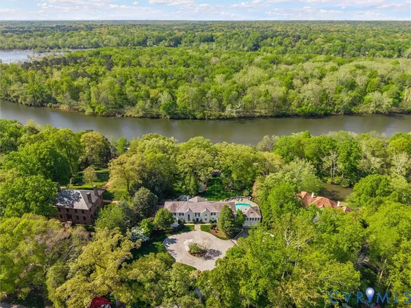 an aerial view of a house with a garden and lake view
