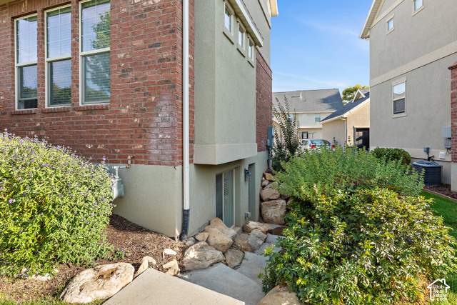 2092 Cres Drive South Mapleton, UT 84664 - Photo 23 of 26 Brick and stucco exterior with multiple windows, concrete steps, and established landscaping