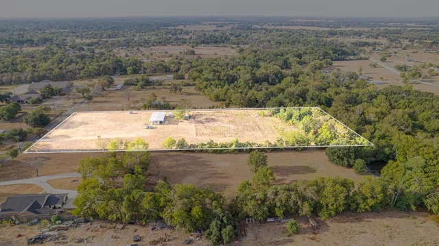 an aerial view of a house with a yard and lake view