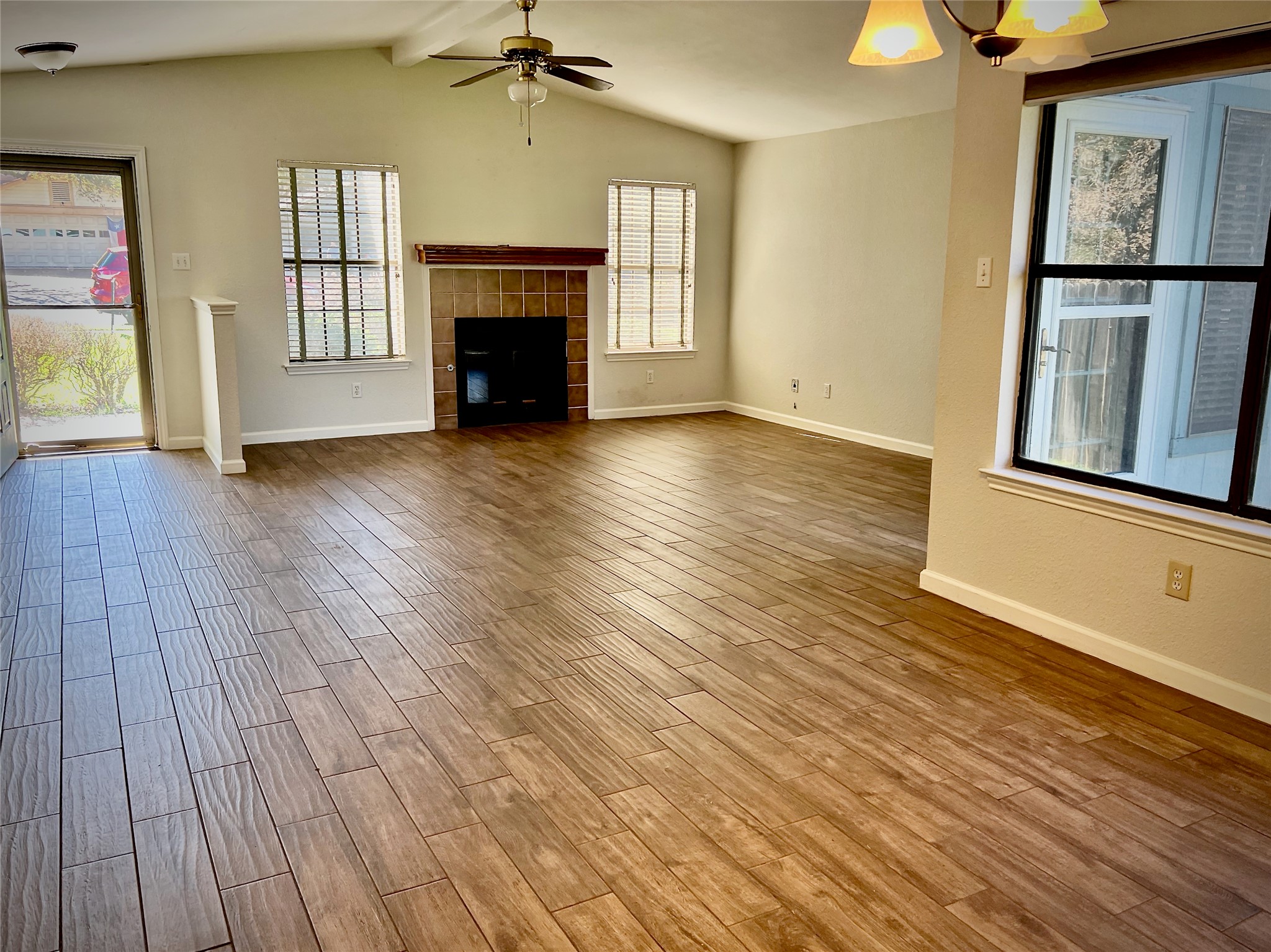 7010 Dallas Drive Austin, TX 78729 - Photo 2 of 14 an empty room with windows fireplace and wooden floor