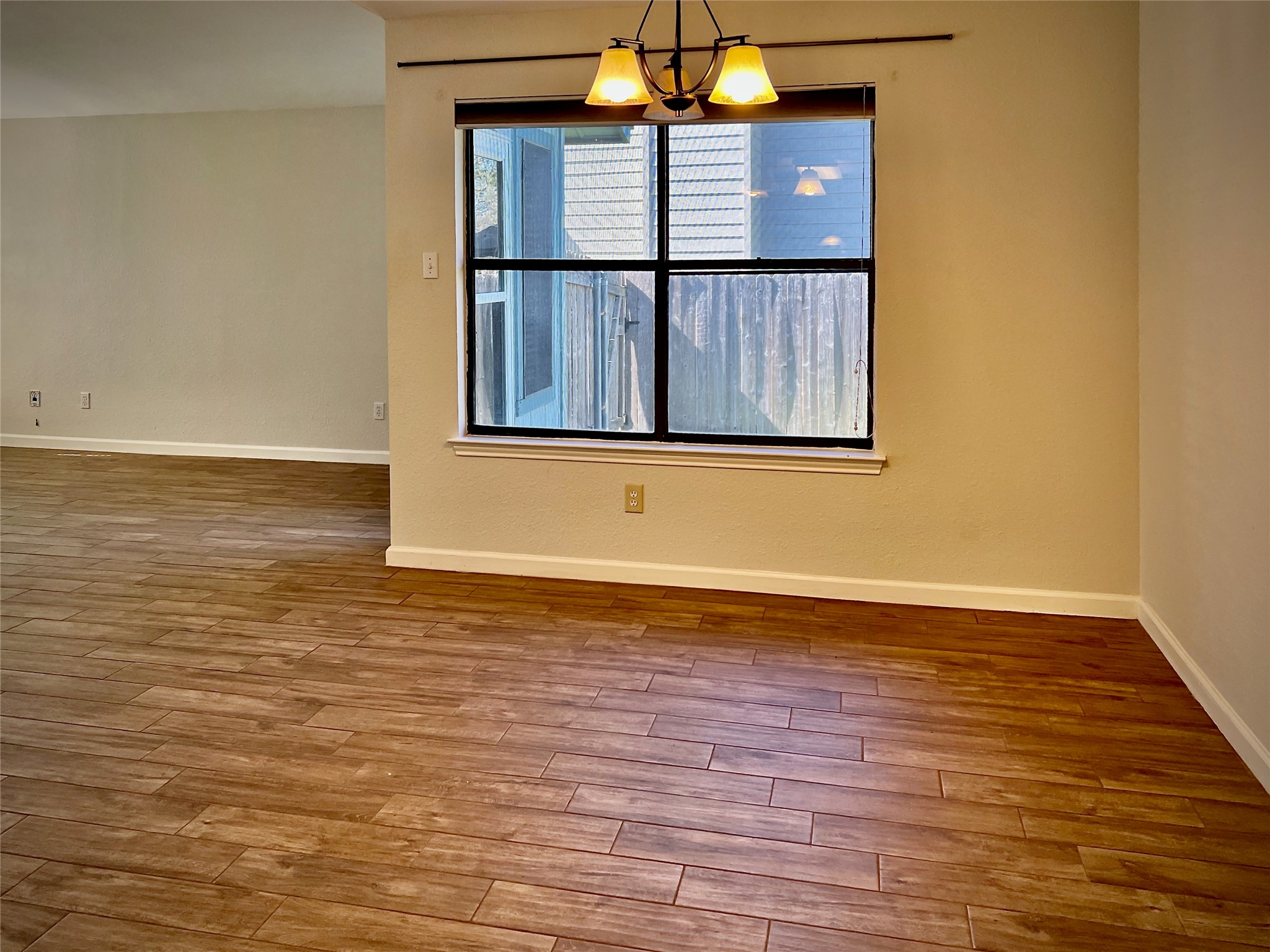 7010 Dallas Drive Austin, TX 78729 - Photo 3 of 14 a view of an empty room with wooden floor and a window