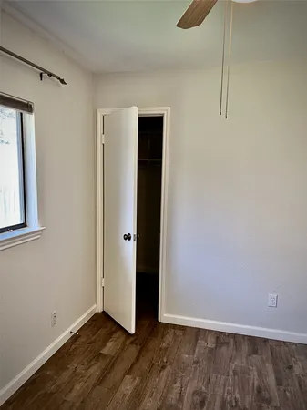 a view of an empty room with closet and a window