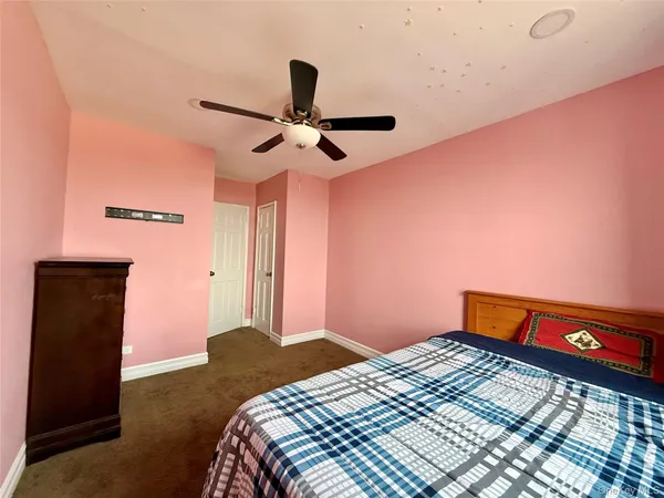 a bedroom with a bed and a chandelier fan