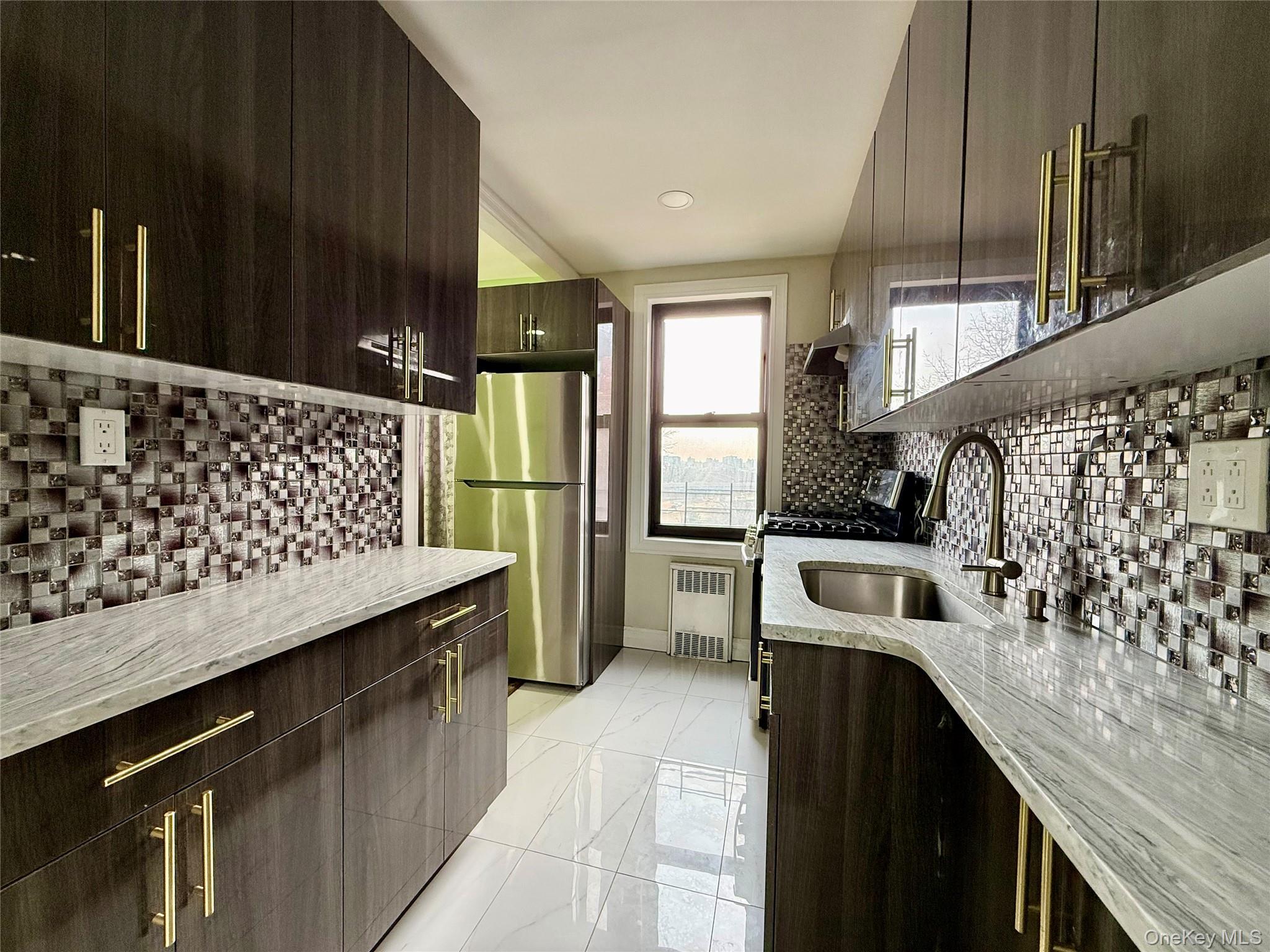 112-30 Northern Boulevard, Unit 4G Queens, NY 11368 - Photo 3 of 38 a kitchen with granite countertop a refrigerator a stove and wooden cabinets