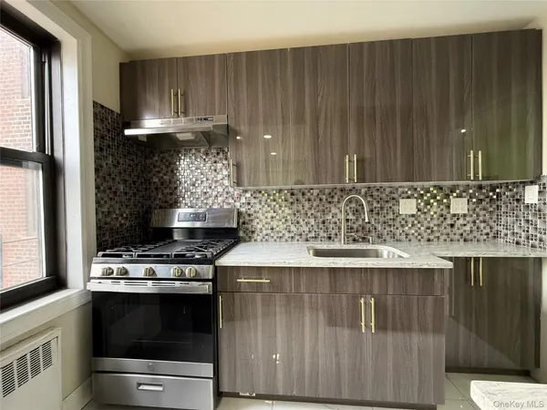a kitchen with granite countertop a stove a sink and a microwave