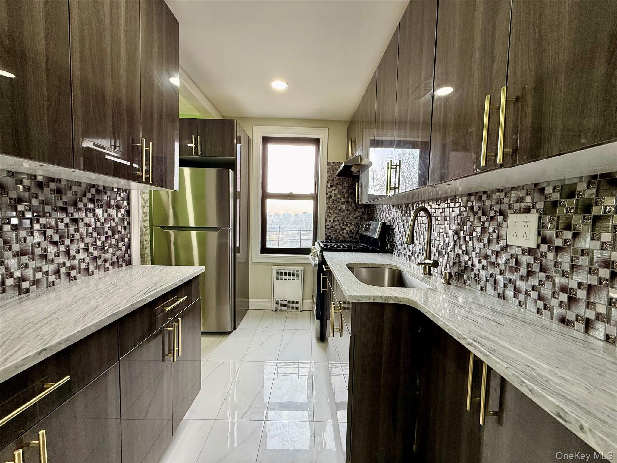 112-30 Northern Boulevard, Unit 4G Queens, NY 11368 - Photo 6 of 38 a kitchen with a sink stove and refrigerator