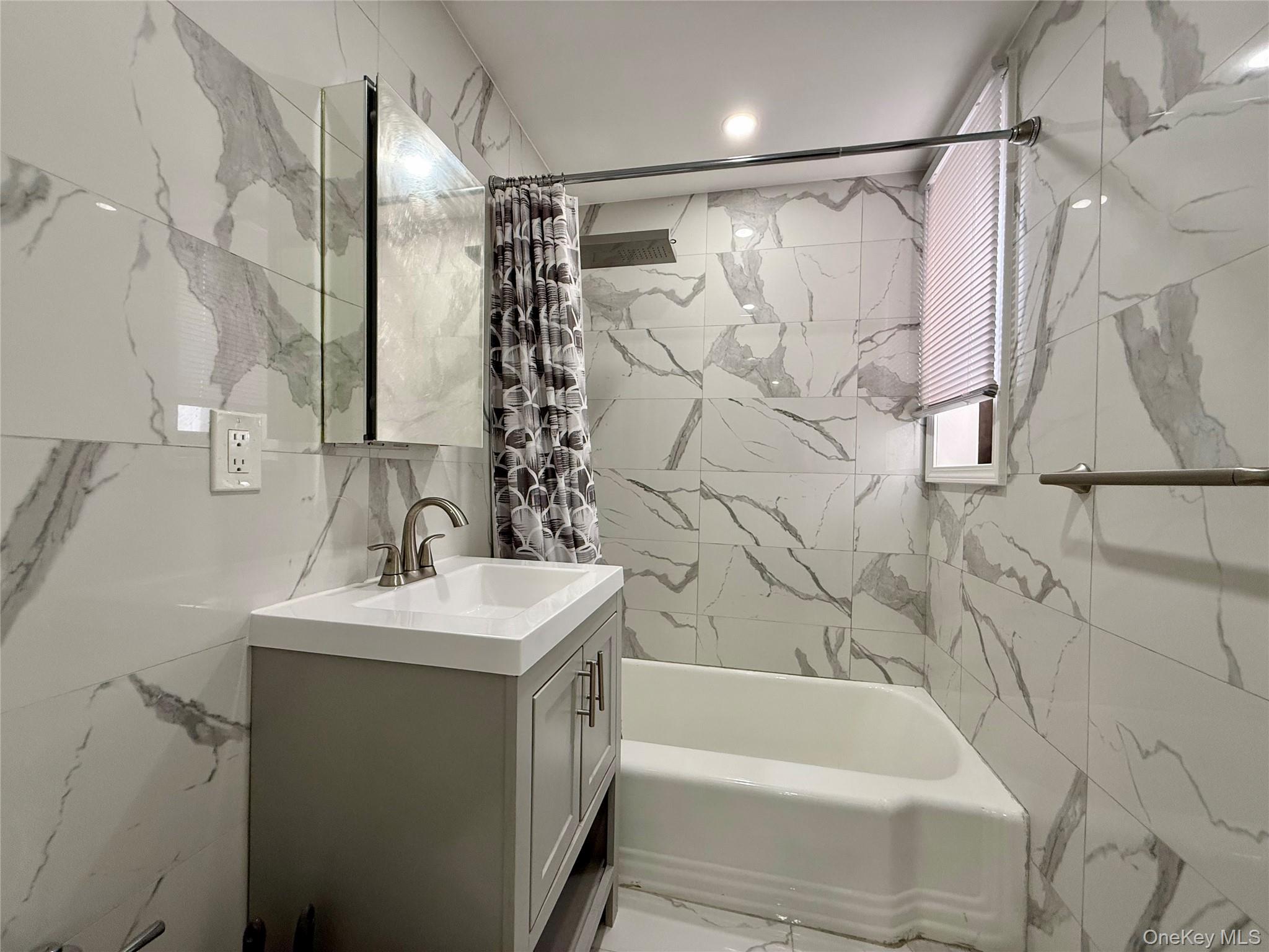 112-30 Northern Boulevard, Unit 4G Queens, NY 11368 - Photo 8 of 38 a bathroom with a sink and a bathtub