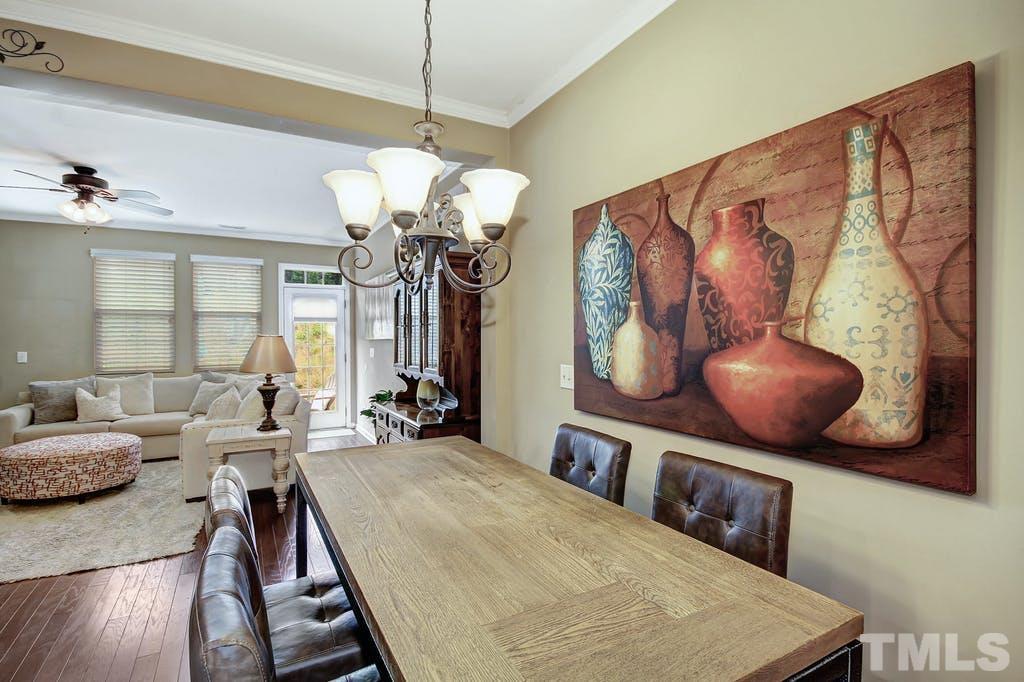 2456 Baslow Drive Apex, NC 27539 - Photo 13 of 39 a living room with large couches chandelier and a dining table with wooden floor
