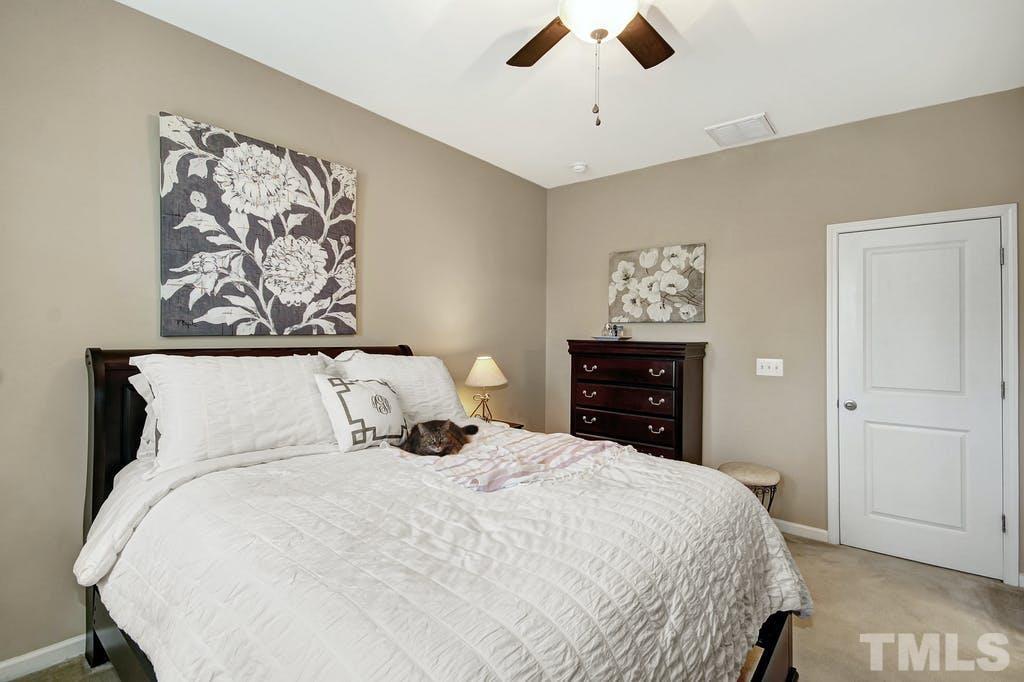 2456 Baslow Drive Apex, NC 27539 - Photo 15 of 39 a bedroom with a bed and a painting on the wall