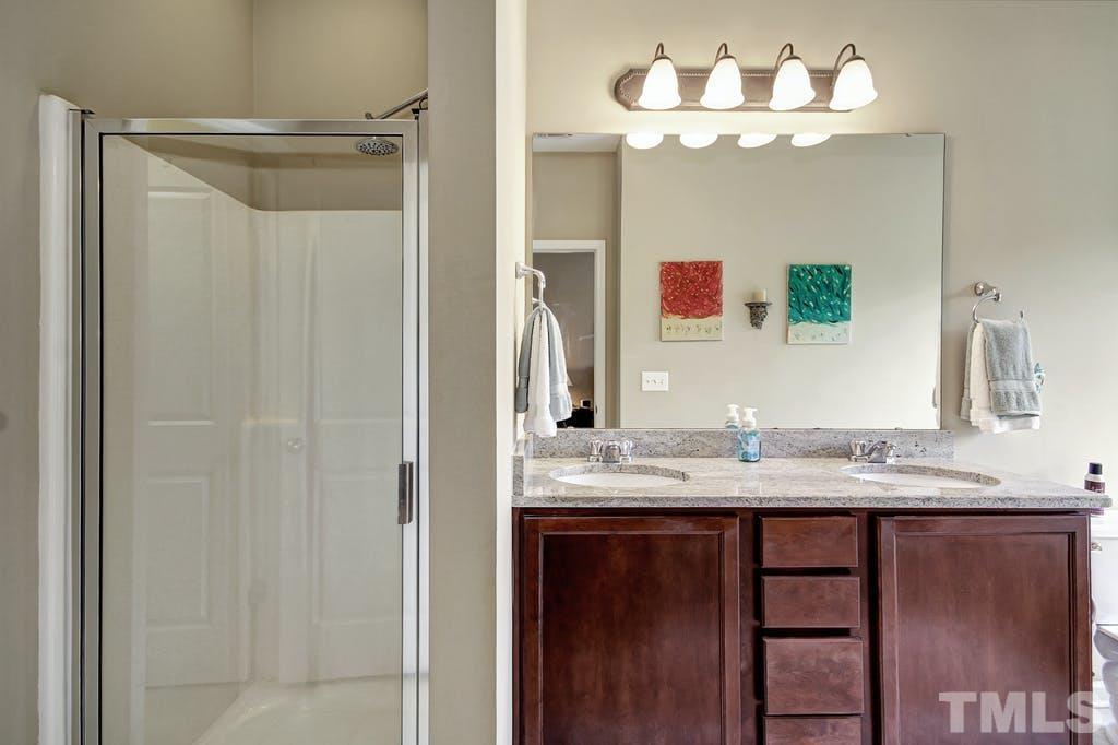 2456 Baslow Drive Apex, NC 27539 - Photo 17 of 39 a bathroom with a granite countertop sink and a mirror