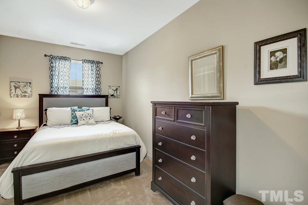 2456 Baslow Drive Apex, NC 27539 - Photo 19 of 39 a bedroom with a bed and a night stand