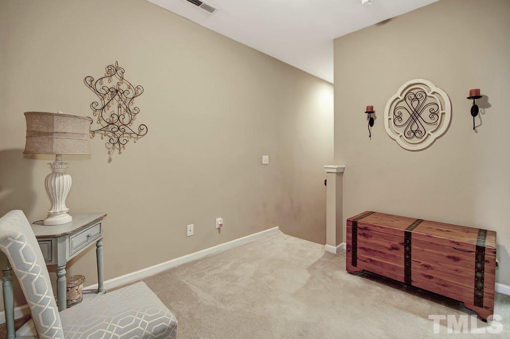 2456 Baslow Drive Apex, NC 27539 - Photo 20 of 39 a bedroom with a bed and a chandelier