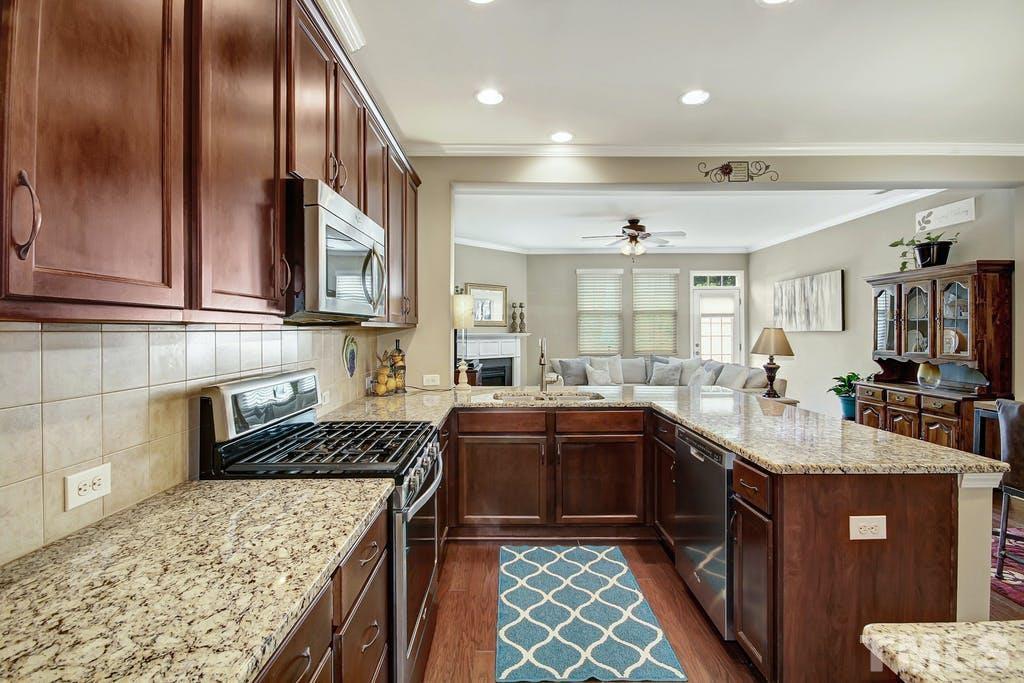 2456 Baslow Drive Apex, NC 27539 - Photo 25 of 39 a kitchen with stainless steel appliances granite countertop a sink stove and cabinets