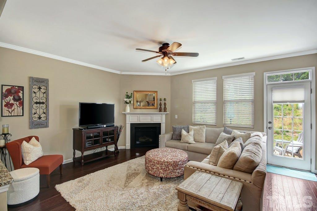 2456 Baslow Drive Apex, NC 27539 - Photo 27 of 39 a living room with furniture a flat screen tv and a large window