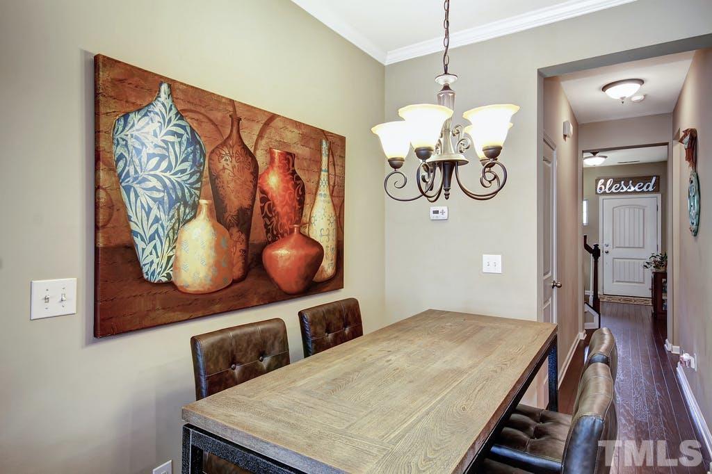 2456 Baslow Drive Apex, NC 27539 - Photo 28 of 39 a bedroom with a bed and a chandelier