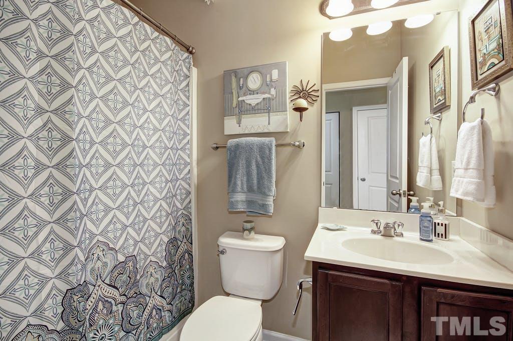 2456 Baslow Drive Apex, NC 27539 - Photo 29 of 39 a bathroom with a sink mirror vanity and toilet