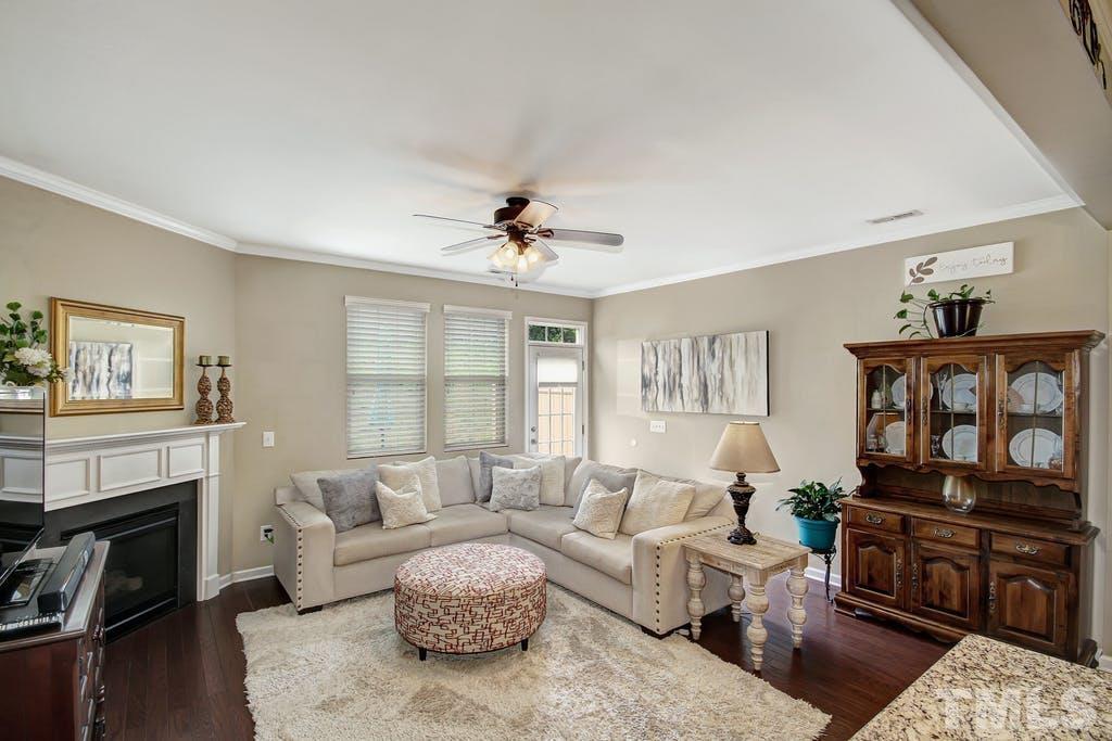 2456 Baslow Drive Apex, NC 27539 - Photo 9 of 39 a living room with furniture a fireplace and a flat screen tv