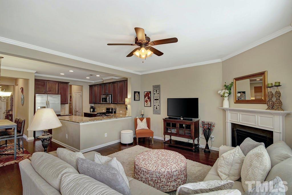 2456 Baslow Drive Apex, NC 27539 - Photo 10 of 39 a living room with furniture a flat screen tv and a fireplace