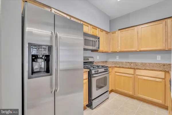 a kitchen with granite countertop a sink stove and cabinets