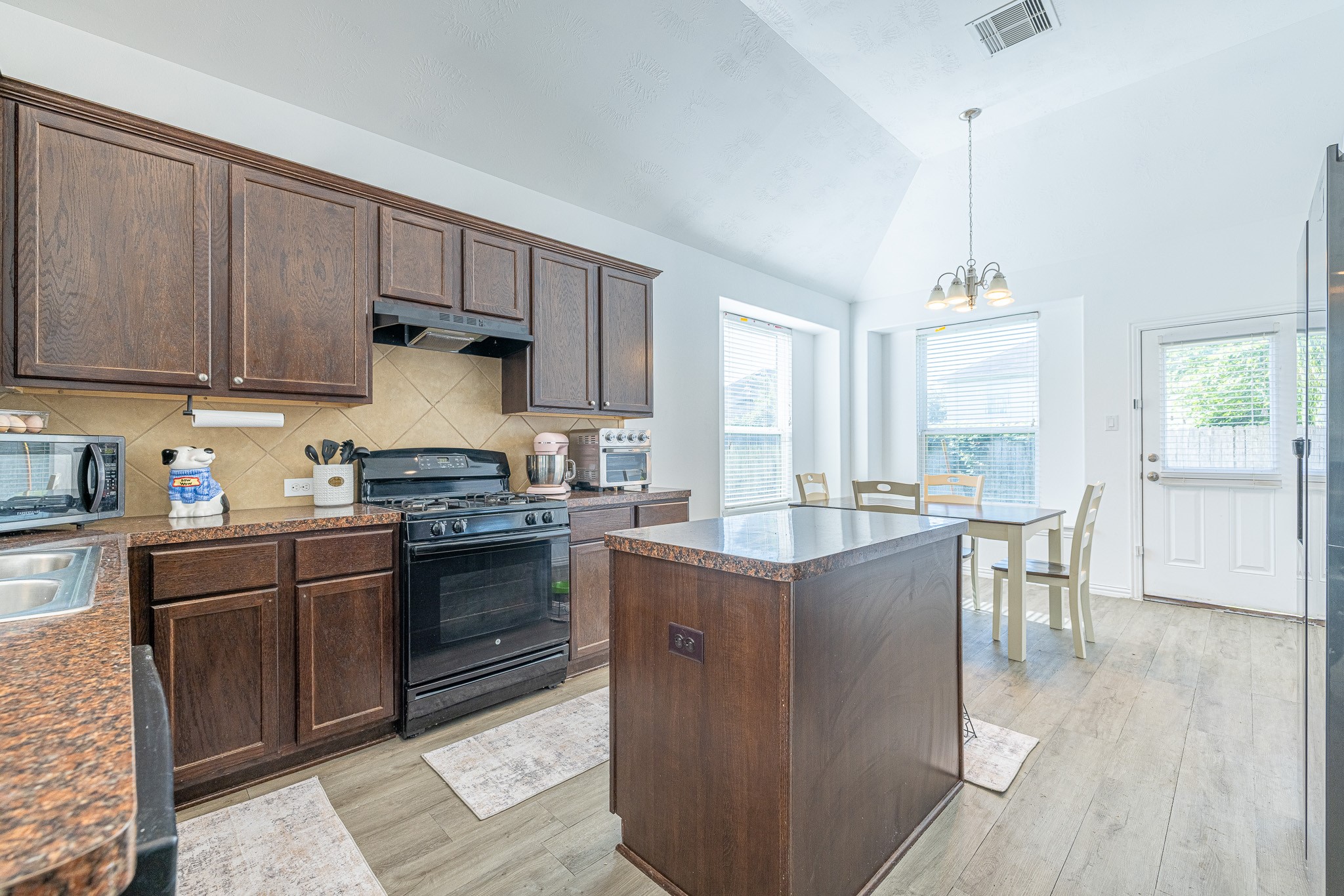 3818 Hunters Trail Baytown, TX 77521 - Photo 9 of 32 a kitchen with stainless steel appliances granite countertop a stove top oven a sink dishwasher and a refrigerator with wooden floor