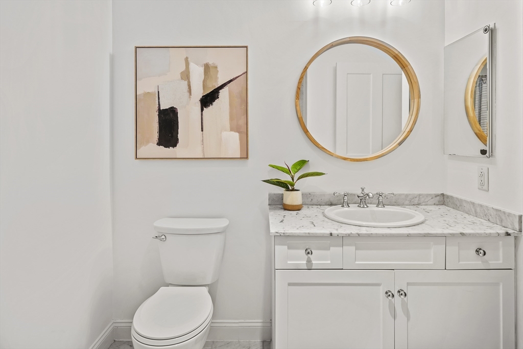 2-14 St Paul Street, Unit 311 Brookline, MA 02446 - Photo 14 of 29 a bathroom with a toilet a sink and a mirror