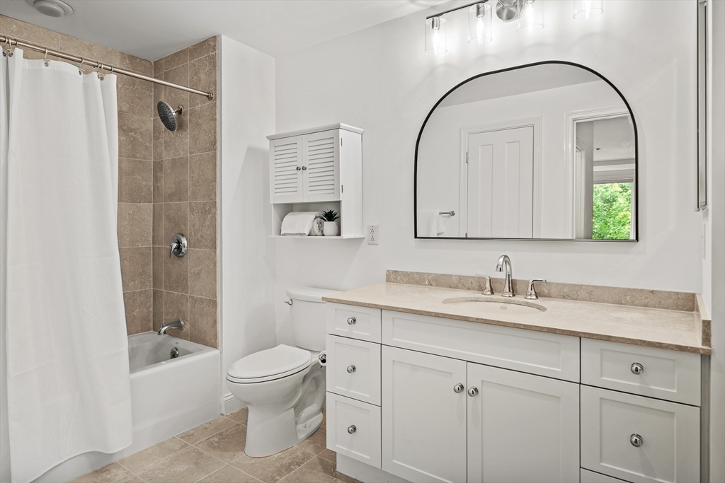 2-14 St Paul Street, Unit 311 Brookline, MA 02446 - Photo 18 of 29 a bathroom with a toilet a sink a mirror a bathtub and vanity