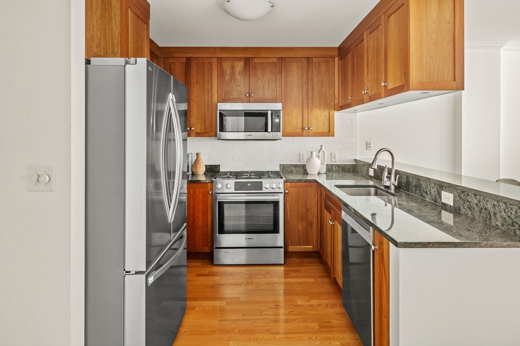 2-14 St Paul Street, Unit 311 Brookline, MA 02446 - Photo 2 of 29 a kitchen with stainless steel appliances granite countertop a refrigerator and a sink