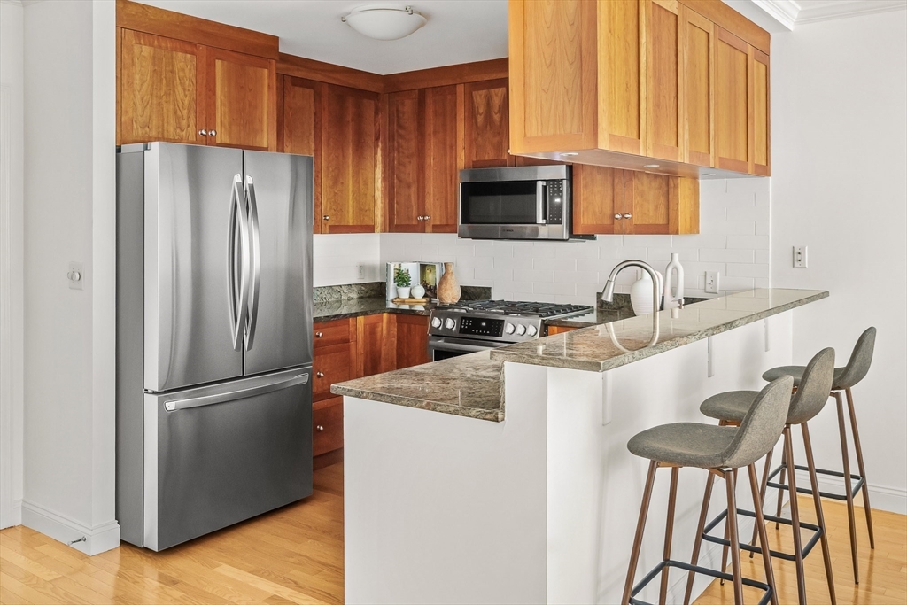 2-14 St Paul Street, Unit 311 Brookline, MA 02446 - Photo 3 of 29 a kitchen with stainless steel appliances granite countertop a refrigerator sink and cabinets