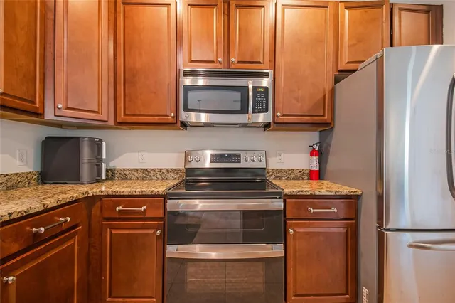 a kitchen with stainless steel appliances granite countertop a refrigerator stove and sink