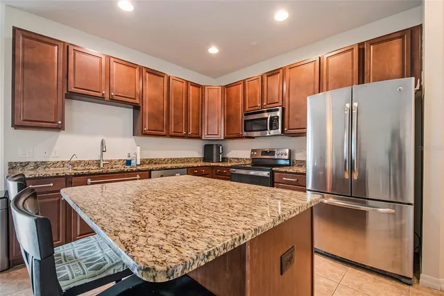 a kitchen with a refrigerator a stove top oven a sink and cabinets