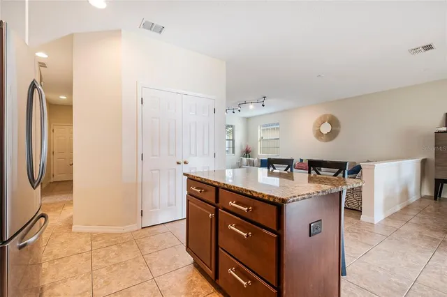 a kitchen with kitchen island granite countertop a sink stove and refrigerator